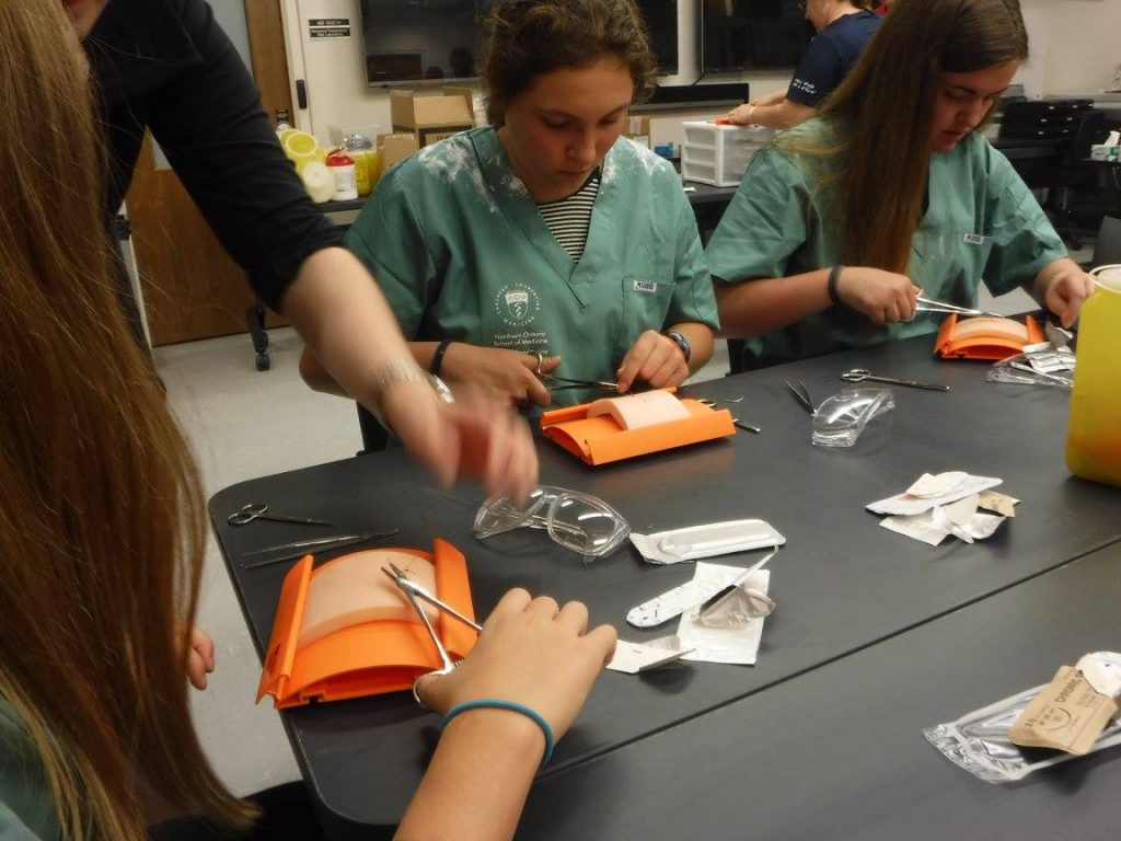 Campers practicing suturing technique