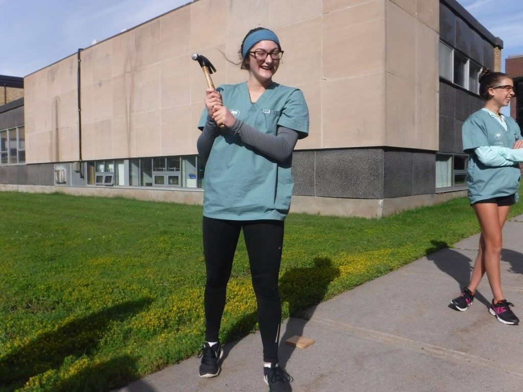 Camper gleefully poses with hammer outside for blood spatter analysis