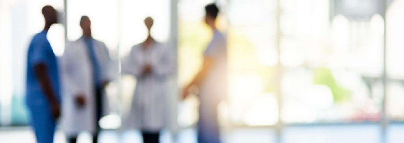 Blurred shot of a team of doctors standing together in a clinical setting