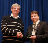 Photo of Dr. David Boyle receiving an award, shaking hands with the award presenter