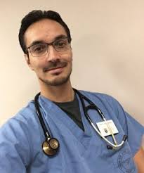 Photo of Kevin Brousseau in scrubs with a stethescope around his neck.