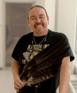 Photo of Indigenous Knowledge Keeper Perry McLeod-Shabogesic holding an eagle feather