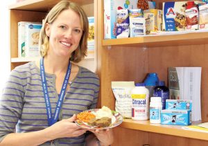 Female dietitian showing food portion sizes for a nutrition counselling session.