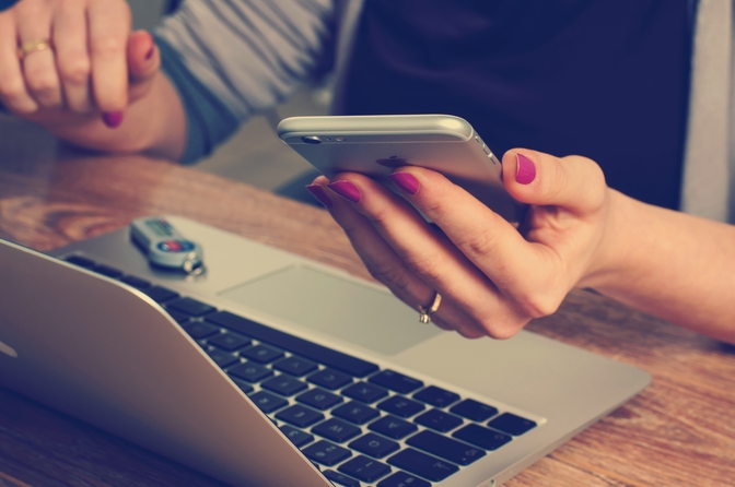 Woman at desk with phone and computer