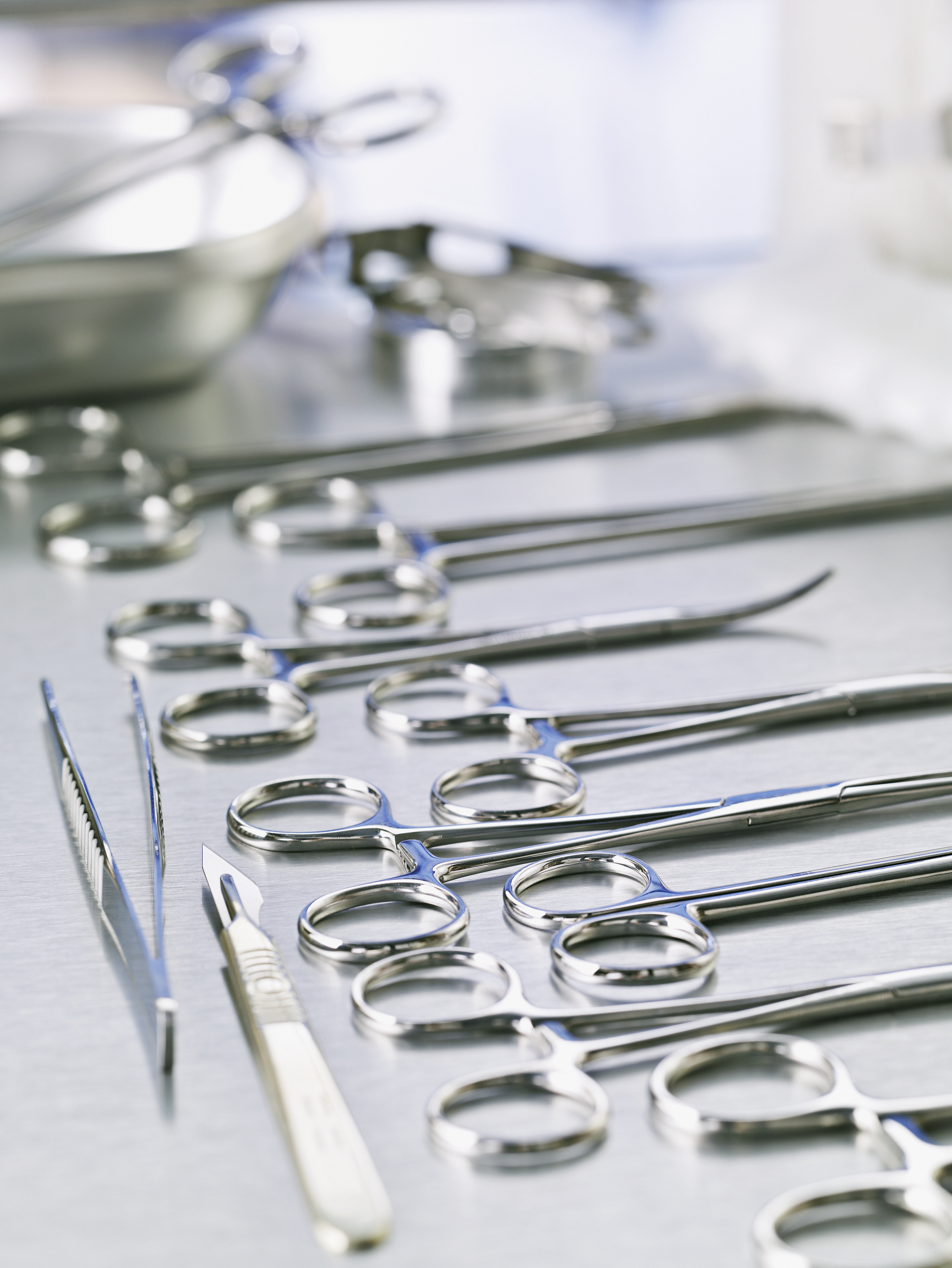 Medical scissors and scalpel on surgical table.