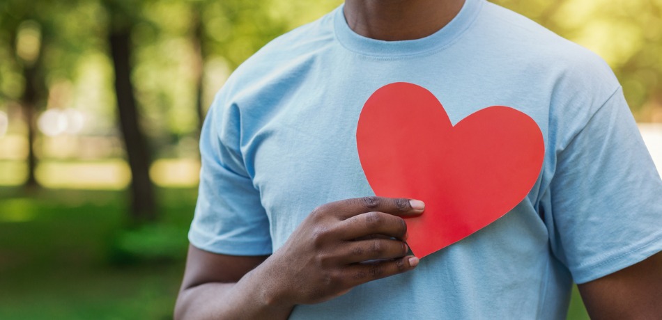 black-man-holding-red-heart-on-his-chest-picture-id1145183163