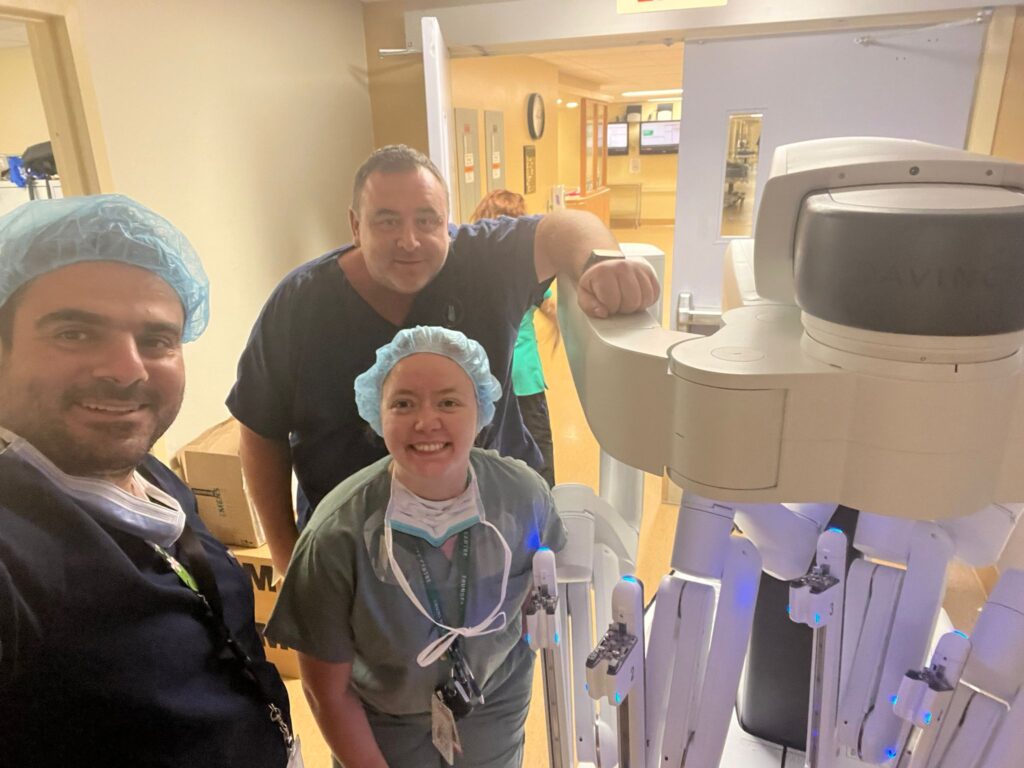 3 doctors posing next to medical equipment in hospital