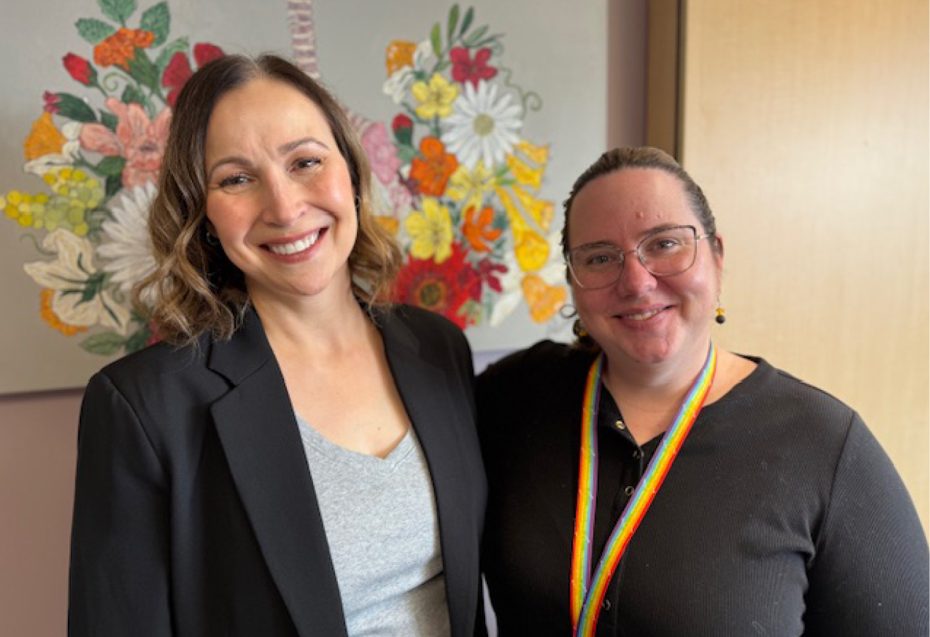 Dr. Stacey Santi and Lacey Pitre in front of a floral painting